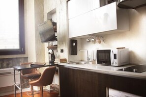 A compact kitchen with a central island, a microwave, a kettle, and a sink. - The Model's Apartment - Urban Loft 56 Moscova - Fashion & Design Heart of Milano (Milan)