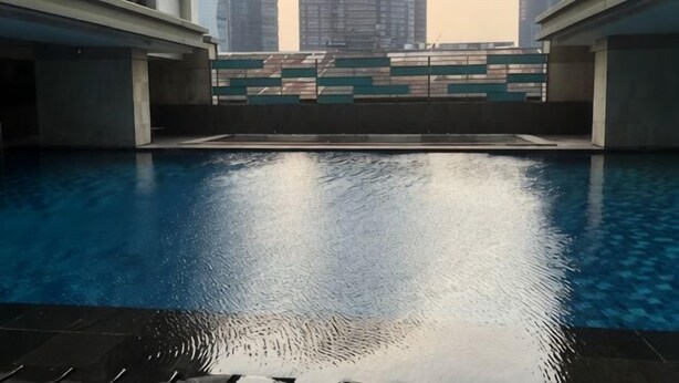 A swimming pool with a view of tall buildings in the background. - Taman Sari Sudirman Studio Deluxe B / Near MRT / Central Jakarta (South Jakarta)
