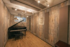 A room with a grand piano, wooden walls, and a ceiling with recessed lighting. - Studio House Grand Piano / near JR Shinjuku stn　 (Tokyo)