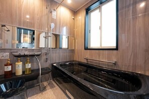 A modern bathroom with a large bathtub, a shower, and a vanity with a mirror. - Studio House Grand Piano / near JR Shinjuku stn　 (Tokyo)