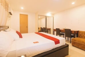 Una habitación de hotel con cama, escritorio y sofá.