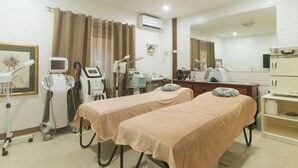 Un consultorio médico con dos camillas de exploración, un escritorio con ordenador y equipo médico.