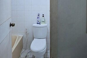 A small, clean bathroom with a toilet, a white sink, and a shower. - Winland JY7 Cebu by RedDoorz (Cebu City)
