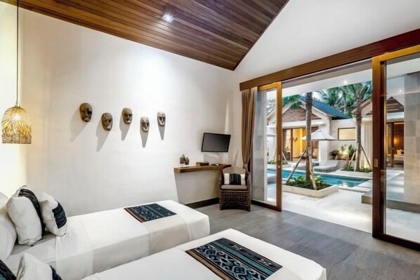 A modern room with a sofa, a television, and a pool view. - Villa Zen Paradise by BaliSuperHost (Bali)