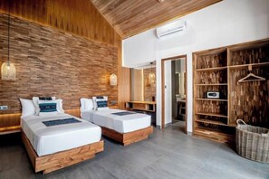 Habitación de hotel con dos camas, una pared de madera, un armario y una cesta colgante.