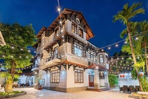 A multi-story building with balconies, string lights, and a sign with 'KN' on it. - KN5 Holiday Villa (Ho Chi Minh City)