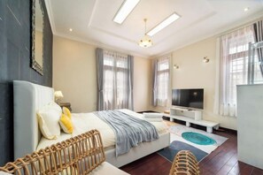 A modern bedroom with a bed, bedside table, TV, and a large window. - KN5 Holiday Villa (Ho Chi Minh City)