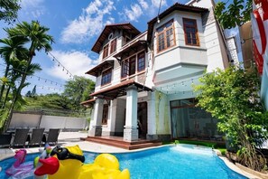 A two-story house with a swimming pool, outdoor seating, and a balcony. - KN5 Holiday Villa (Ho Chi Minh City)