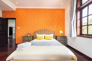 Une chambre d’hôtel avec un grand lit, deux tables de chevet et une fenêtre avec des rideaux.