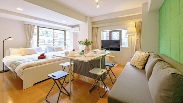 A modern hotel room with a bed, a sofa, a dining table, and a TV. - Land Forest Ryogoku (Tokyo)