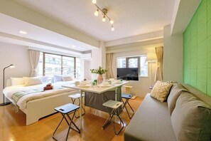 A modern hotel room with a bed, a sofa, a dining table, and a TV. - Land Forest Ryogoku (Tokyo)