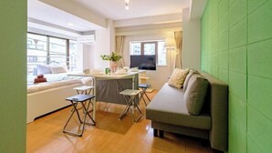A compact living space with a sofa, a dining table, and a TV. - Land Forest Ryogoku (Tokyo)
