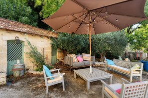 An outdoor seating area with a table and chairs, a swing, and a covered umbrella. - Guest Room "Little Boudha Room" with Shared Terrace, Wi-Fi, and Air Conditioning (Bernis)