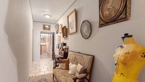 A hallway with a mannequin, framed pictures, and a patterned rug. - Guest Room "Little Boudha Room" with Shared Terrace, Wi-Fi, and Air Conditioning (Bernis)