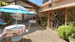 A courtyard with outdoor seating, bicycles, and a rustic building. - Guest Room "Little Boudha Room" with Shared Terrace, Wi-Fi, and Air Conditioning (Bernis)