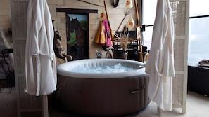 A hot tub in a room with a view, a horse statue, and a rustic decor. - Guest Room "Little Boudha Room" with Shared Terrace, Wi-Fi, and Air Conditioning (Bernis)