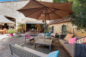 An outdoor seating area with tables, chairs, and a large umbrella. - Guest Room "Little Boudha Room" with Shared Terrace, Wi-Fi, and Air Conditioning (Bernis)