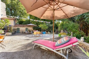 A patio with a lounge chair, a table, and a hanging umbrella. - Guest Room "Little Boudha Room" with Shared Terrace, Wi-Fi, and Air Conditioning (Bernis)
