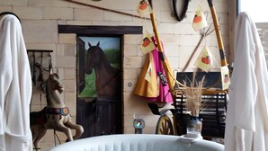A room with a horse statue, a door with a horse painting, a hot tub, and various hanging decorations. - Guest Room 'Chambre Marcel Pagnol' with Shared Terrace, Wi-Fi and Air Conditioning (Bernis)