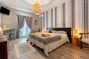Un dormitorio con una cama grande, un escritorio, una silla y una lámpara colgante.