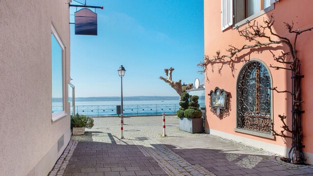 A paved pathway leading to a building with a view of the sea, a street lamp, and a decorative iron gate. - Room 'Doppelzimmer Austria' with Wi-Fi (Meersburg)