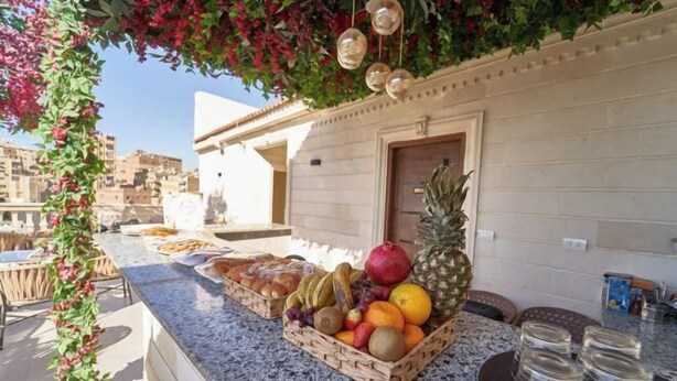 Un balcon agrémenté d’un panier de fruits, d’un ananas et de décorations suspendues.