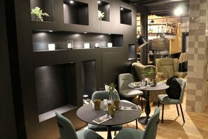 A modern interior with a round dining table, chairs, and a bar area. - Swissôtel Amsterdam (Amsterdam)