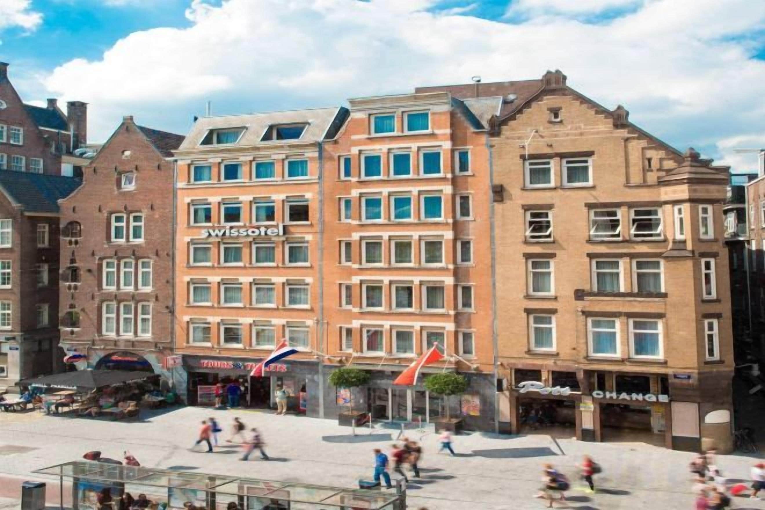 Een hotel met meerdere verdiepingen, een opvallend ‘swissotel’ bord en een straat ervoor met voetgangers.