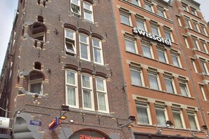 A multi-story building with a prominent 'Swissotel' sign, indicating it is a hotel. - Swissôtel Amsterdam (Amsterdam)
