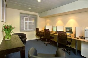 A conference room with a long table, several chairs, a computer, and a printer. - Swissôtel Amsterdam (Amsterdam)