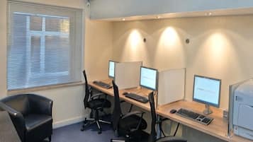 Een werkplek met kantoormeubels, computers en een printer.