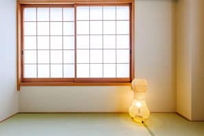 A room with tatami flooring, a shoji screen window, and a traditional Japanese paper lantern. - Bliss KAMEARI (Tokyo)