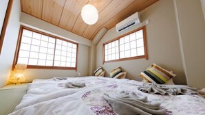 Una habitación tradicional japonesa con suelo de tatami, techo bajo y puertas correderas de papel.
