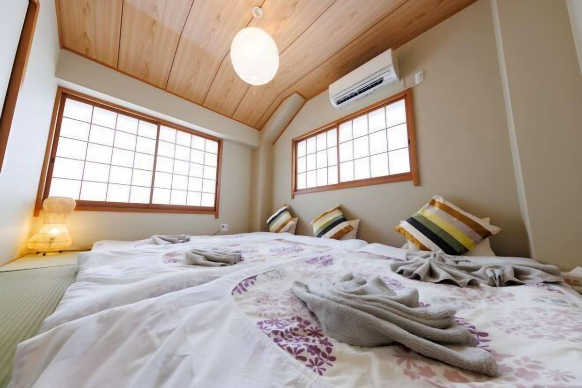 A traditional Japanese-style room with tatami flooring, a low ceiling, and shoji screens.