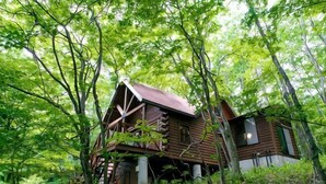 A rustic cabin surrounded by dense forest. - Log House Nasu High Grand (Nasu)