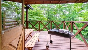 A wooden deck with benches and a grill, overlooking a forested area. - Log House Nasu High Grand (Nasu)