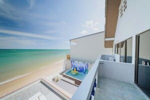 Un balcon avec vue sur la plage et l’océan.