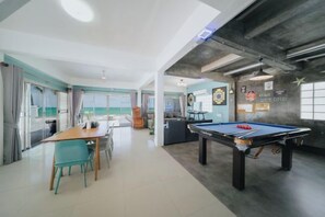 A spacious room with a pool table, a dining area, and a kitchen. - Gao Bee One Beach Club (Ban Chang)