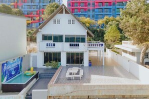 A two-story building with a swimming pool and outdoor seating area. - Gao Bee One Beach Club (Ban Chang)