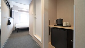 A hotel room with a bed, a small kitchenette with a coffee maker, and a TV mounted on the wall. - Hop Inn Tokyo Ueno (Tokyo)