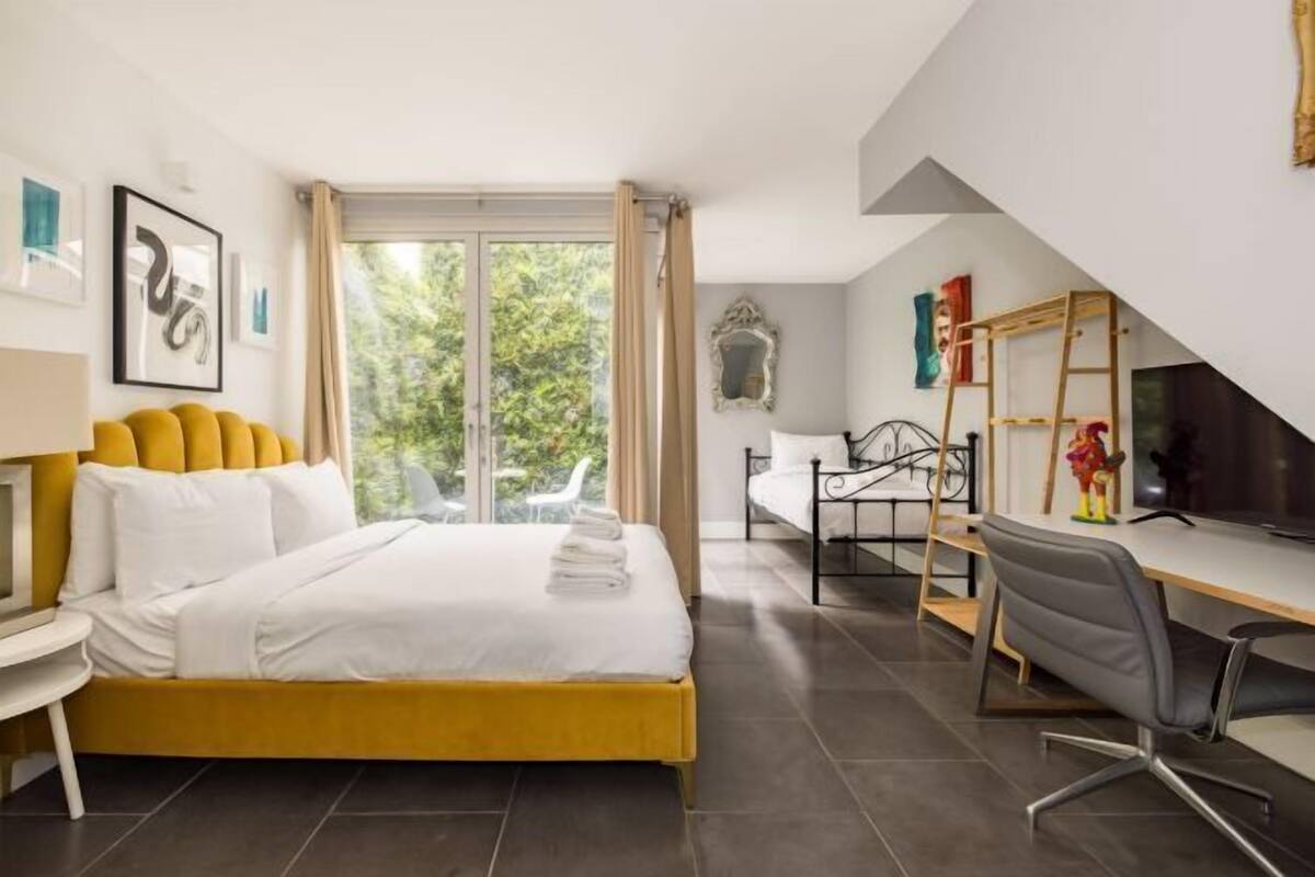 A modern bedroom with a bed, a desk, and a chair.