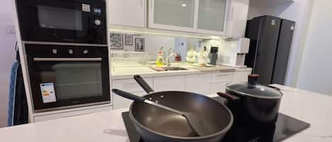 Una cocina moderna con horno integrado, estufa y una olla grande.