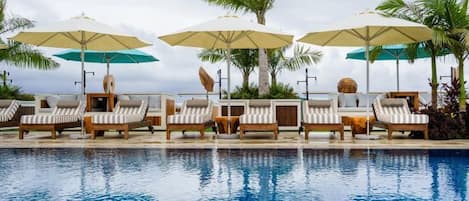 A poolside area with lounge chairs and umbrellas.