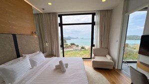 Una habitación de hotel moderna con una cama grande, un área de descanso y un televisor.