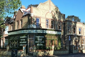 A building with a signboard advertising Truman Hanbury Buxton & Co. C.C. Ales & Porter, including Truman's Noted Ales & Stout, Truman's Barrelled Ales & Stout, and Bottled Beers. - Unique 2 bedroom Flat in Heart of Walthamstow (Waltham Forest)