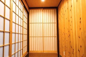 A traditional Japanese room with tatami flooring, shoji screens, and wooden paneling. - Haku Flower's Seven (Kyoto)
