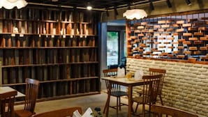 Ein Restaurantinneres mit Holzbögen, Backsteinwänden und Holztischen und -stühlen.