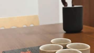 A table with four ceramic cups and a potted plant.