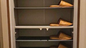 Un zapatero con varias repisas, cada una con un par de zapatos marrones.