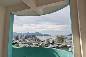 Ein Balkon mit Blick auf einen Hafen und ferne Berge.